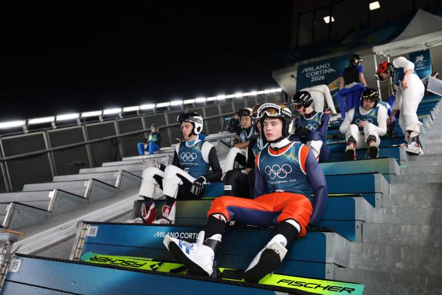 Athletes including Finland's Vilho Palosaari (C) prepare for a jump during the men's ski jumping normal hill training of the Milano Cortina 2026 Winter Olympic Games at Predazzo Ski Jumping Stadium in Predazzo (Val di Fiemme), on February 5, 2026. (Photo by Anne-Christine POUJOULAT / AFP)
