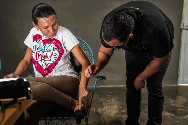 A physician checks a Huntington’s patient at a volunteer medical clinic in the neighborhood of San Luis in Maracaibo, Zulia state, Venezuela, on January 30, 2026. The Lake Maracaibo region in Venezuela holds the world’s highest concentration of Huntington’s disease (HD), with a prevalence of roughly 700 per 100,000 in certain areas. (Photo by Maryorin Mendez / AFP)