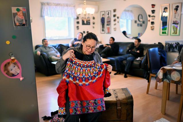 (FILES) Dorthe Olsen shows traditional clothes at her house at the settlement Sarfannguit, near Sisimiut, Greenland on February 1, 2026. Dorthe Olsen scrolls through photos on her iPad from her grandson’s first hunt. In Sarfannguit, a village of barely 100 souls tucked into Greenland’s fjords, the teacher refuses to let American turbulence disrupt her daily life. (Photo by Ina FASSBENDER / AFP)