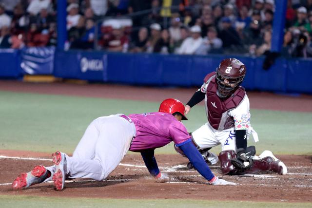 Leones del Escogido's #38 Jimmy Paredes slides to home in front of Tomateros de Culiacan's #44 Ali Solis in the fourth inning of the Caribbean Series baseball tournament tenth game between Dominican Republic's Leones del Escogido and Mexico's Tomateros de Culiacan at the Panamerican Stadium in Jalisco, Mexico, on February 5, 2026. (Photo by Ulises Ruiz / AFP)