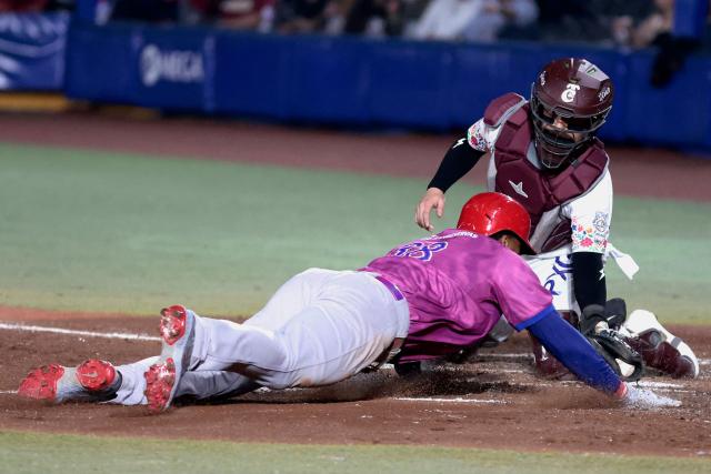 Leones del Escogido's #38 Jimmy Paredes slides to home in front of Tomateros de Culiacan's #44 Ali Solis in the fourth inning of the Caribbean Series baseball tournament tenth game between Dominican Republic's Leones del Escogido and Mexico's Tomateros de Culiacan at the Panamerican Stadium in Jalisco, Mexico, on February 5, 2026. (Photo by Ulises Ruiz / AFP)