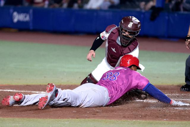 Leones del Escogido's #38 Jimmy Paredes slides to home in front of Tomateros de Culiacan's #44 Ali Solis in the fourth inning of the Caribbean Series baseball tournament tenth game between Dominican Republic's Leones del Escogido and Mexico's Tomateros de Culiacan at the Panamerican Stadium in Jalisco, Mexico, on February 5, 2026. (Photo by Ulises Ruiz / AFP)