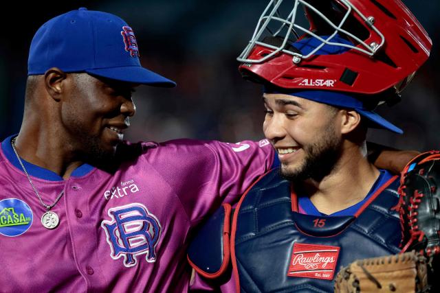 Leones del Escogido's #42 Radhames Liz embraces his teammate #21 Geraldi Diaz in the fourth inning of the Caribbean Series baseball tournament tenth game between Dominican Republic's Leones del Escogido and Mexico's Tomateros de Culiacan at the Panamerican Stadium in Jalisco, Mexico, on February 5, 2026. (Photo by Ulises Ruiz / AFP)
