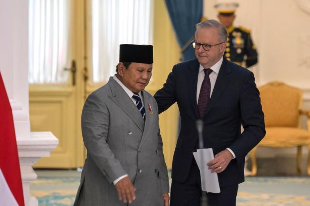 Indonesian President Prabowo Subianto (L) and Australian Prime Minister Anthony Albanese (R) walk together during a  meeting at the Merdeka Palace in Jakarta on February 6, 2026. (Photo by BAY ISMOYO / AFP)