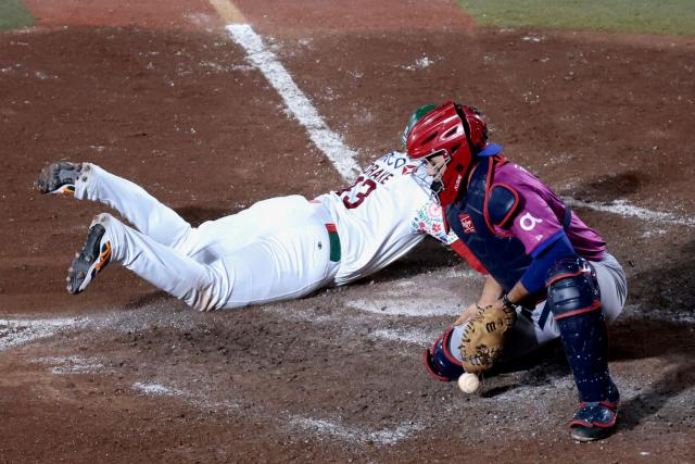 Tomateros de Culiacan's #33 Yadir Drake slides to home as Leones del Escogido's #21 Geraldi Diaz tries to catch the ball in the eight inning of the Caribbean Series baseball tournament tenth game between Dominican Republic's Leones del Escogido and Mexico's Tomateros de Culiacan at the Panamerican Stadium in Jalisco, Mexico, on February 5, 2026. (Photo by Ulises Ruiz / AFP)