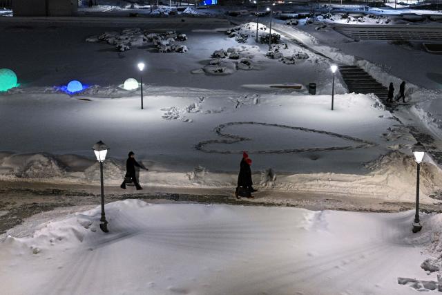 People walk at the Zaryadye park in central Moscow on February 5, 2026. (Photo by Hector RETAMAL / AFP)