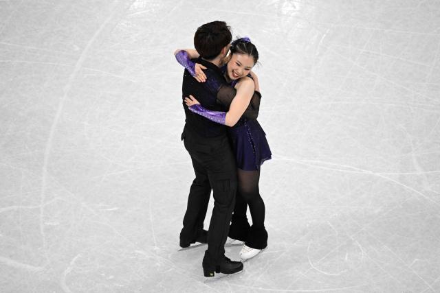 Japan's Utana Yoshida (R) and Masaya Morita embrace each other after competing in the figure skating team event ice dance-rhythm dance during the Milano Cortina 2026 Winter Olympic Games at Milano Ice Skating Arena in Milan on February 6, 2026. (Photo by Antonin THUILLIER / AFP)