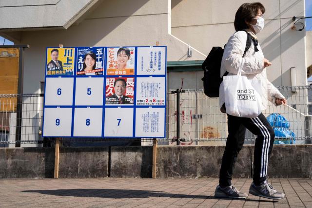 A woman walks past campaign posters of candidates running for the upcoming House of Representatives election, in Inagi, Tokyo prefecture on February 6, 2026. (Photo by Yuichi YAMAZAKI / AFP)