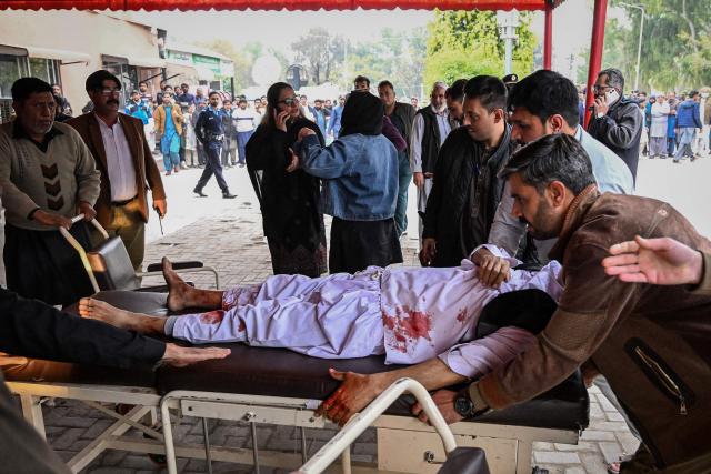 EDITORS NOTE: Graphic content / People shift an injured man to a hospital following an explosion at a mosque in Islamabad on February 6, 2026. A blast at a Shiite mosque in Pakistan's capital Islamabad on February 6 killed 11 people and wounded 20, a police source told AFP. (Photo by Aamir QURESHI / AFP)
