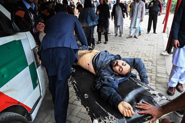 EDITORS NOTE: Graphic content / People shift an injured man to a hospital following an explosion at a mosque in Islamabad on February 6, 2026. A blast at a Shiite mosque in Pakistan's capital Islamabad on February 6 killed 11 people and wounded 20, a police source told AFP. (Photo by Aamir QURESHI / AFP)