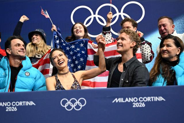USA's Madison Chock (bottom row, 2L) and USA's Evan Bates (bottom row, 2R) react after competing in the figure skating team event ice dance-rhythm dance during the Milano Cortina 2026 Winter Olympic Games at Milano Ice Skating Arena in Milan on February 6, 2026. (Photo by WANG Zhao / AFP)