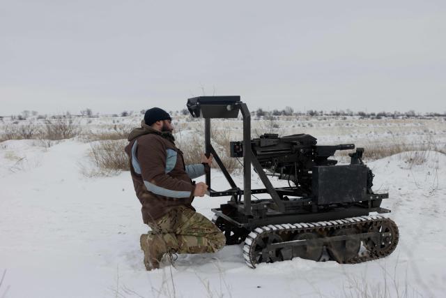 A Ukrainian serviceman of the 30th separate mechanized brigade tests a robotic combat vehicle armed with an Mk 19 grenade launcher at an undisclosed location in Donetsk region on January 27, 2026, amid the Russian invasion of Ukraine. (Photo by Tetiana DZHAFAROVA / AFP)