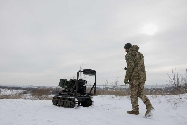 TOPSHOT - A Ukrainian serviceman of the 30th separate mechanized brigade prepares an unmanned robotic ground vehicle armed with an Mk 19 grenade launcher to test at an undisclosed location in Donetsk region on January 27, 2026, amid the Russian invasion of Ukraine. (Photo by Tetiana DZHAFAROVA / AFP)