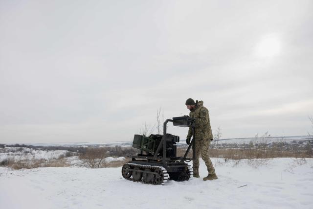 A Ukrainian serviceman of the 30th separate mechanized brigade prepares a robotic combat vehicle armed with an Mk 19 grenade launcher to test at an undisclosed location in Donetsk region on January 27, 2026, amid the Russian invasion of Ukraine. (Photo by Tetiana DZHAFAROVA / AFP)