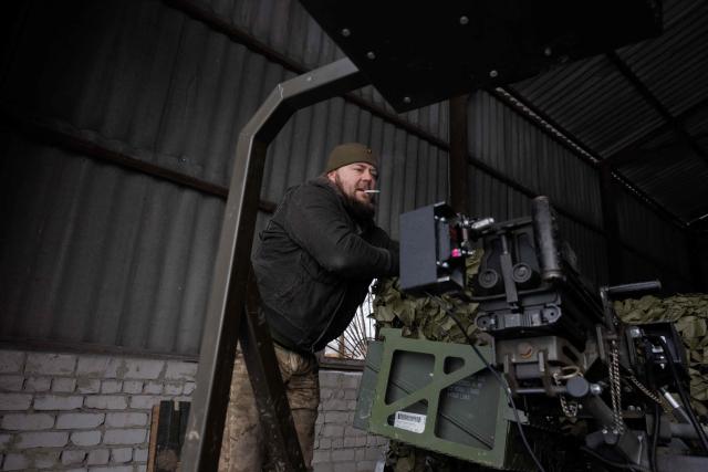 A Ukrainian serviceman of the 30th separate mechanized brigade fixes a robotic combat vehicle armed with an Mk 19 grenade launcher on a military vehicle after testing it at an undisclosed location in Donetsk region on January 27, 2026, amid the Russian invasion of Ukraine. (Photo by Tetiana DZHAFAROVA / AFP)
