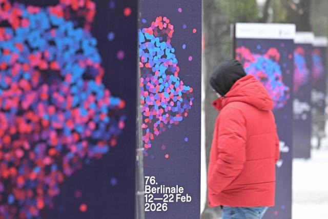 A man walks past advertising posters of the 76th Berlin International Film Festival 'Berlinale' in front of the Berlinale Palace in Berlin, on February 6, 2026. The 76th Berlinale edition will be running from February 12 to 22, 2026. (Photo by RALF HIRSCHBERGER / AFP)