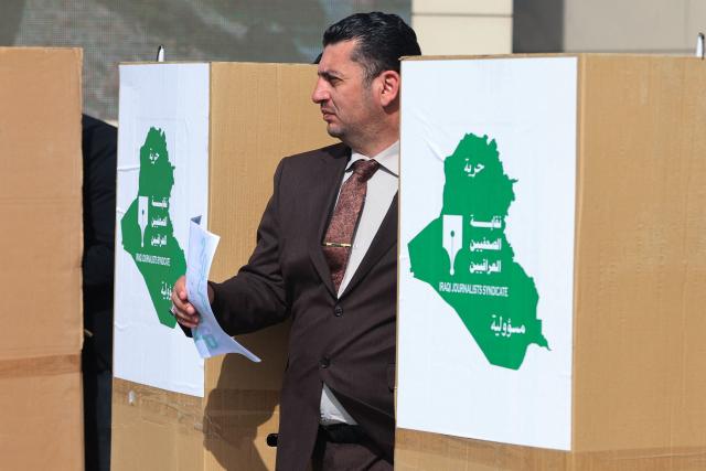 An Iraqi journalist casts his votes in the 23rd session of the Iraqi Journalists Syndicate, which takes place every four years, in Baghdad on February 6, 2026. The voting will elect a president to represent the Iraqi Journalists Syndicate and syndicate members. (Photo by AHMAD AL-RUBAYE / AFP)