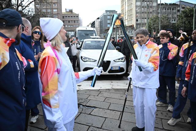IOC President Kirsty Coventry (L) and former Olympic rower Anita DeFranz take part in the torch relay of the Olympic flame ahead of the Milano Cortina 2026 Winter Olympic Games, in Milan on February 6, 2026. (Photo by Daniel MUNOZ / AFP)