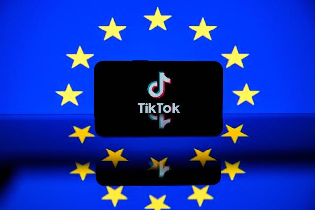 (FILES) This photograph shows a screen displaying the Tiktok social media platform's logo and the European flag on April 26, 2023 in Toulouse, southwestern France. The EU said on February 6, 2026, that it had told TikTok it needs to change its "addictive design" or risk heavy fines, after the Chinese-owned platform was found in breach of the bloc's digital content rules. (Photo by Lionel BONAVENTURE / AFP)