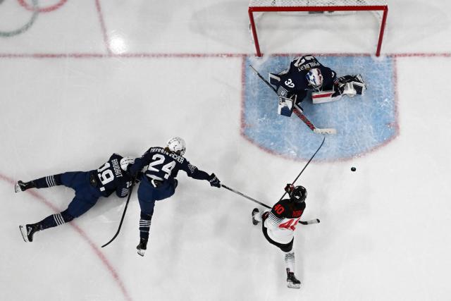 Japan's #40 Rio Noro (2R) vies for the puck with France's forward #19 Lore Baudrit, France's forward #24 Emma Nonnenmacher and France's goalkeeper #32 Alice Philbert during the women's preliminary round Group B Ice Hockey match between France and Japan at the Milano Rho Ice Hockey Arena at the Milano Cortina 2026 Winter Olympic Games in Milan, on February 6, 2026. (Photo by Wikus de WET / AFP)