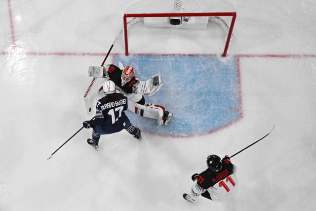 France's forward #17 Chloe Aurard (C) vies for the puck with Japan's #20 Miyuu Masuhara during the women's preliminary round Group B Ice Hockey match between France and Japan at the Milano Rho Ice Hockey Arena at the Milano Cortina 2026 Winter Olympic Games in Milan, on February 6, 2026. (Photo by Wikus de WET / AFP)