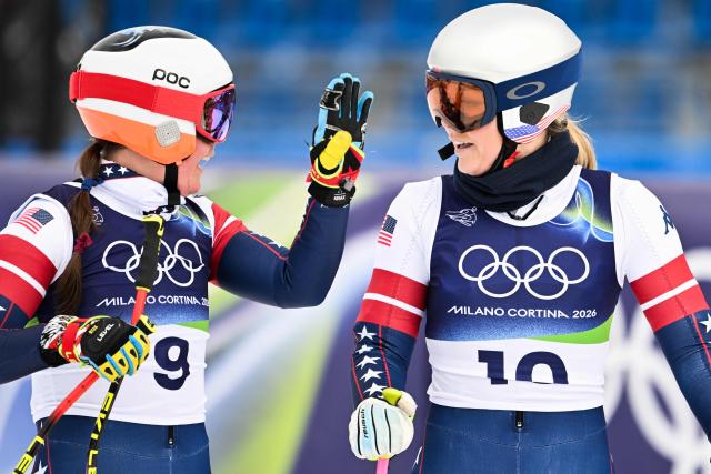 USA's Breezy Johnson (L) and USA's Lindsey Vonn (R) look on in the finish line area after taking part in the second official training for the women's downhill event ahead of the Milano Cortina 2026 Winter Olympic Games at the Tofane Alpine Skiing Centre in Cortina d’Ampezzo on February 6, 2026. (Photo by Tiziana FABI / AFP)