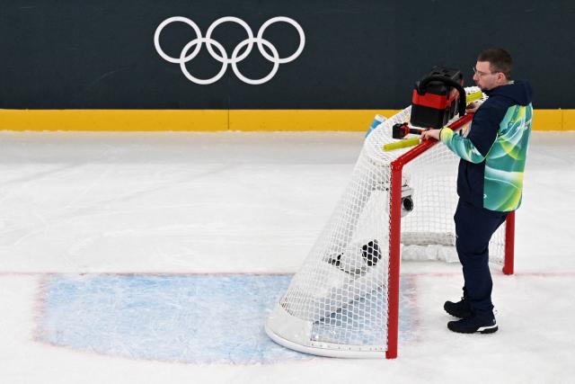 A technician sets up the goal during a break of the women's preliminary round Group B Ice Hockey match between France and Japan at the Milano Rho Ice Hockey Arena at the Milano Cortina 2026 Winter Olympic Games in Milan, on February 6, 2026. (Photo by Wikus de WET / AFP)