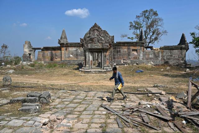 An official walks at the Preah Vihear temple in Preah Vihear province on February 6, 2026. Chunks of broken sandstone litter Cambodia's UNESCO-listed Preah Vihear temple, whose centuries-old sandstone facades are pocked with fresh shrapnel scars after weeks of deadly border clashes with neighbouring Thailand. Considered a masterpiece of Khmer architecture that looks out over the northern Cambodian plains, the temple became a war zone when a longstanding border dispute erupted into fighting with jets, artillery, tanks and ground troops last year. (Photo by TANG CHHIN Sothy / AFP) / To go with 'CAMBODIA-THAILAND-CONFLICT-HERITAGE, REPORTAGE' by Suy SE