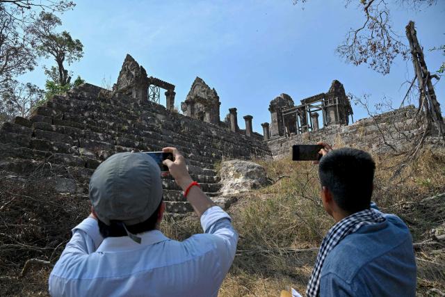 Officials take pictures of the Preah Vihear temple in Preah Vihear province on February 6, 2026. Chunks of broken sandstone litter Cambodia's UNESCO-listed Preah Vihear temple, whose centuries-old sandstone facades are pocked with fresh shrapnel scars after weeks of deadly border clashes with neighbouring Thailand. Considered a masterpiece of Khmer architecture that looks out over the northern Cambodian plains, the temple became a war zone when a longstanding border dispute erupted into fighting with jets, artillery, tanks and ground troops last year. (Photo by TANG CHHIN Sothy / AFP) / To go with 'CAMBODIA-THAILAND-CONFLICT-HERITAGE, REPORTAGE' by Suy SE