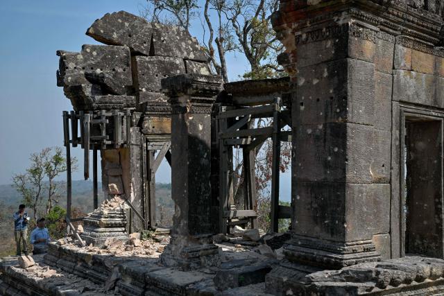 Officials inspect the damage at Preah Vihear temple in Preah Vihear province on February 6, 2026. Chunks of broken sandstone litter Cambodia's UNESCO-listed Preah Vihear temple, whose centuries-old sandstone facades are pocked with fresh shrapnel scars after weeks of deadly border clashes with neighbouring Thailand. Considered a masterpiece of Khmer architecture that looks out over the northern Cambodian plains, the temple became a war zone when a longstanding border dispute erupted into fighting with jets, artillery, tanks and ground troops last year. (Photo by TANG CHHIN Sothy / AFP) / To go with 'CAMBODIA-THAILAND-CONFLICT-HERITAGE, REPORTAGE' by Suy SE