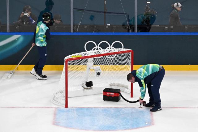 A technician sets up the goal during a break of the women's preliminary round Group B Ice Hockey match between France and Japan at the Milano Rho Ice Hockey Arena at the Milano Cortina 2026 Winter Olympic Games in Milan, on February 6, 2026. (Photo by Wikus de WET / AFP)