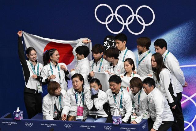 Japan's Kaori Sakamoto (bottom C) reacts with team mates after competing in the figure skating women's single short program team event during the Milano Cortina 2026 Winter Olympic Games at Milano Ice Skating Arena in Milan on February 6, 2026. (Photo by Antonin THUILLIER / AFP)