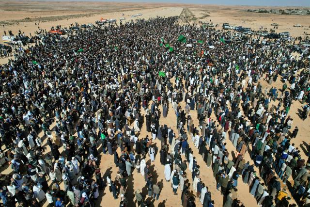 This aerial picture shows Libyans gathered for the funeral of Seif al-Islam Gaddafi, the son of Libya's late longtime ruler, in Bani Walid, in the Tripoli region, western Libya on February 6, 2026. Seif al-Islam, 53, the son of Libya's late longtime ruler, had been seen by some as his father's successor, despite being targeted by a warrant from the International Criminal Court for alleged crimes against humanity. He was killed on February 3, 2026, by gunmen who stormed his home in western Libya's Zintan, his French lawyer told AFP. (Photo by Mahmud Turkia / AFP)