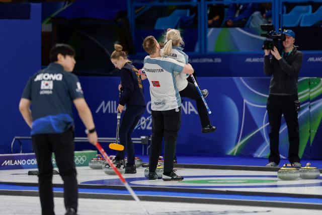 Norway's Magnus Nedregotten (CL) and Norway's Kristin Skaslien (CR) celebrate after winning the curling mixed doubles round robin between Sweden and Norway during the Milano Cortina 2026 Winter Olympic Games at the Cortina Curling Olympic Stadium in Cortina d’Ampezzo on February 6, 2026. (Photo by Odd ANDERSEN / AFP)