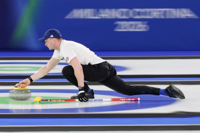 Britain's Bruce Mouat curls the stone in the curling mixed doubles round robin between South Korea and Britain during the Milano Cortina 2026 Winter Olympic Games at the Cortina Curling Olympic Stadium in Cortina d’Ampezzo on February 6, 2026. (Photo by Odd ANDERSEN / AFP)