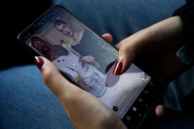 A teenager  scrolls through social media on her phone in Tomares, Seville on February 6, 2026. Spain will seek to ban social media for under-16s to protect them from harmful content such as pornography and violence, Prime Minister Pedro Sanchez said on February 3, 2026, drawing a furious response from X owner Elon Musk and Telegram founder Pavel Durov who slammed Spanish prime minister over his "dangerous" plan to ban social media for under-16s. (Photo by Cristina Quicler / AFP)