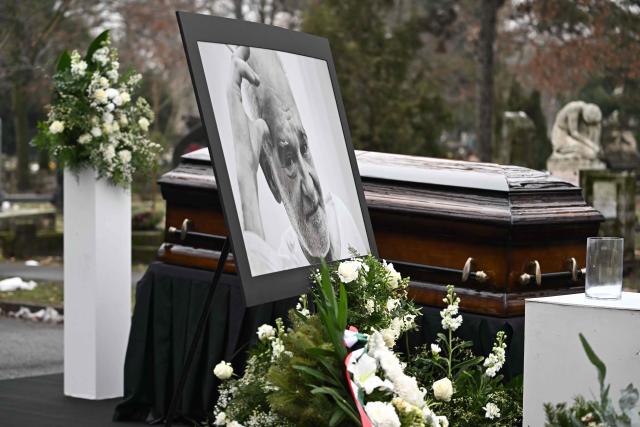 A picture of Hungarian filmmaker Bela Tarr and his coffin are displayed on his funeral at the Fiumei Road Cemetery of Budapest, Hungary, on February 6, 2026, one month after his death. Legendary Hungarian filmmaker Bela Tarr, known for his long takes, monochromatic movies and depictions of desolate landscapes on the silver screen, died on January 6, 2026 at the age of 70. Tarr was best known for the movie "Satantango (1994), a seven-hour epic about the collapse of communism in Eastern Europe and its material and spiritual decline. (Photo by Attila KISBENEDEK / AFP)