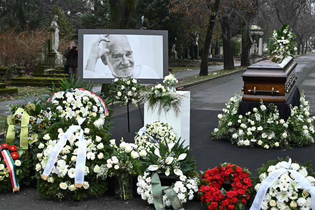 A picture of Hungarian filmmaker Bela Tarr and his coffin are displayed on his funeral at the Fiumei Road Cemetery of Budapest, Hungary, on February 6, 2026, one month after his death. Legendary Hungarian filmmaker Bela Tarr, known for his long takes, monochromatic movies and depictions of desolate landscapes on the silver screen, died on January 6, 2026 at the age of 70. Tarr was best known for the movie "Satantango (1994), a seven-hour epic about the collapse of communism in Eastern Europe and its material and spiritual decline. (Photo by Attila KISBENEDEK / AFP)