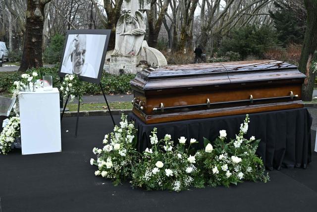 A picture of Hungarian filmmaker Bela Tarr and his coffin are displayed on his funeral at the Fiumei Road Cemetery of Budapest, Hungary, on February 6, 2026, one month after his death. Legendary Hungarian filmmaker Bela Tarr, known for his long takes, monochromatic movies and depictions of desolate landscapes on the silver screen, died on January 6, 2026 at the age of 70. Tarr was best known for the movie "Satantango (1994), a seven-hour epic about the collapse of communism in Eastern Europe and its material and spiritual decline. (Photo by Attila KISBENEDEK / AFP)