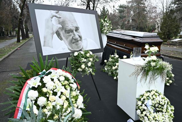 A picture of Hungarian filmmaker Bela Tarr is dislpayed on his funeral at the Fiumei Road Cemetery of Budapest, Hungary, on February 6, 2026, one month after his death. Legendary Hungarian filmmaker Bela Tarr, known for his long takes, monochromatic movies and depictions of desolate landscapes on the silver screen, died on January 6, 2026 at the age of 70. Tarr was best known for the movie "Satantango (1994), a seven-hour epic about the collapse of communism in Eastern Europe and its material and spiritual decline. (Photo by Attila KISBENEDEK / AFP)