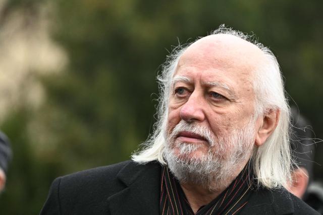 Hungarian writer and winner of the 2025 Nobel Prize in Literature Laszlo Krasznahorkai looks on during the funeral of Hungarian filmmaker Bela Tarr at the Fiumei Road Cemetery of Budapest, Hungary, on February 6, 2026, one month after his death. Legendary Hungarian filmmaker Bela Tarr, known for his long takes, monochromatic movies and depictions of desolate landscapes on the silver screen, died on January 6, 2026 at the age of 70. Tarr was best known for the movie "Satantango (1994), a seven-hour epic about the collapse of communism in Eastern Europe and its material and spiritual decline. (Photo by Attila KISBENEDEK / AFP)