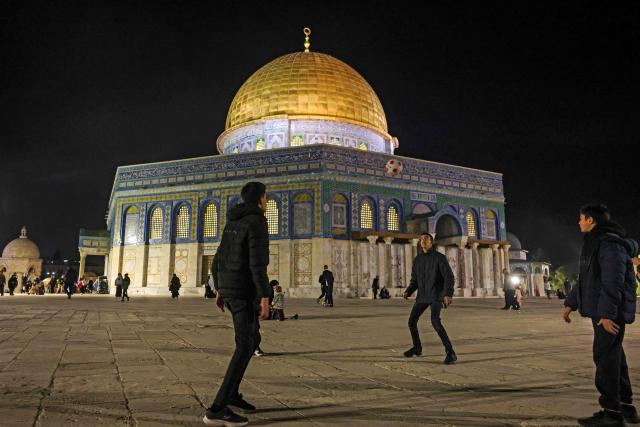 Palestinian youths play with a football outside the Dome of the Rock Shrine at the Aqsa mosque compound in the old city of Jerusalem late on Febuary 6, 2026. (Photo by AHMAD GHARABLI / AFP)