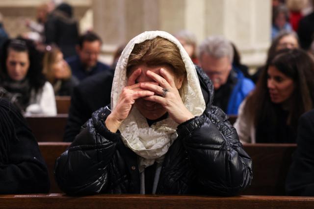 A woman prays as she waits for the start of an installation Mass for Ronald Hicks to become the 11th Archbishop of New York, succeeding Cardinal Timothy Dolan, at St. Patrick’s Cathedral in New York, on February 6, 2026. (Photo by ANGELA WEISS / AFP)
