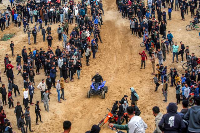 A man performs stunts with an all-terrain vehicle (ATV) on sand dunes near destroyed buildings in the Zahra neighbourhood, southwest of Nuseirat in the central Gaza Strip, on February 6, 2026. Since October 10, a fragile US-sponsored truce in Gaza has largely halted the fighting between Israeli forces and Hamas, but both sides have alleged frequent violations. (Photo by Eyad Baba / AFP)