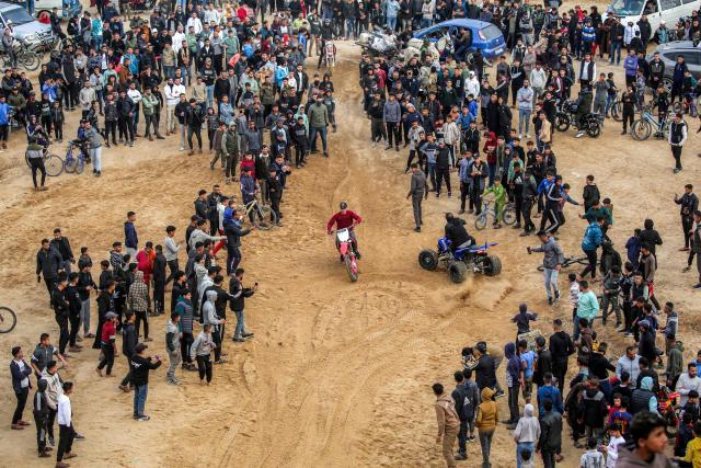 A man performs stunts with a dirt bike on sand dunes near destroyed buildings in the Zahra neighbourhood, southwest of Nuseirat in the central Gaza Strip, on February 6, 2026. Since October 10, a fragile US-sponsored truce in Gaza has largely halted the fighting between Israeli forces and Hamas, but both sides have alleged frequent violations. (Photo by Eyad Baba / AFP)