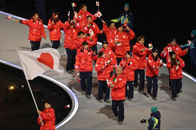 Japan's flag bearer Wataru Morishige parades with other athletes during the opening ceremony of the Milano Cortina 2026 Winter Olympic Games at the San Siro stadium in Milan, northern Italy, on February 6, 2026. (Photo by Piero CRUCIATTI / AFP)