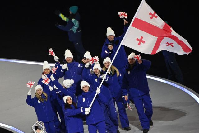 Georgia's flag bearers Diana Davis and Luka Berulava parade with other athletes during the opening ceremony of the Milano Cortina 2026 Winter Olympic Games at the San Siro stadium in Milan, northern Italy, on February 6, 2026. (Photo by Piero CRUCIATTI / AFP)