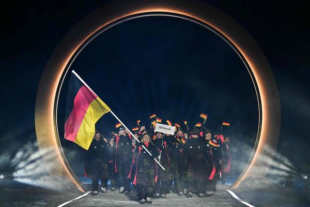 Germany's flag bearer Germany's flag bearer Katharina Schmid (C) and athletes parade during the opening ceremony of the Milano Cortina 2026 Winter Olympic Games at the Predazzo Ski Jumping Stadium in Predazzo (Val di Fiemme), on February 6, 2026. (Photo by Javier SORIANO / AFP)
