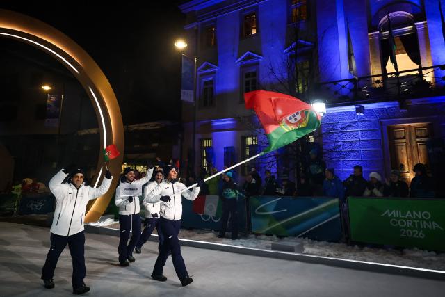 Portugal's flag bearer Vanina Guerillot (R)  parades with members of the delegation during the opening ceremony of the Milano Cortina 2026 Winter Olympic Games in Cortina d'Ampezzo, northern Italy, on February 6, 2026. (Photo by Franck FIFE / AFP)