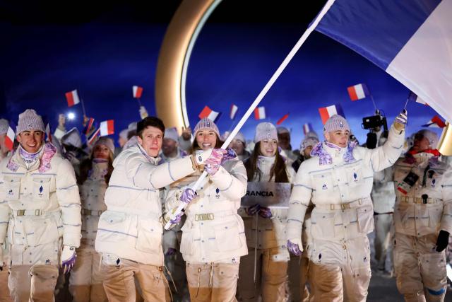 France's flag bearers Clement Noel and Chloe Trespeuch lead the team during the opening ceremony of the Milano Cortina 2026 Winter Olympic Games in Livigno, northern Italy, on February 6, 2026. (Photo by Cameron Spencer / POOL / AFP)